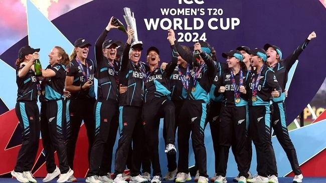 the new zealand players pose with the trophy