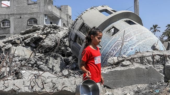 a child walks past the destroyed mosque