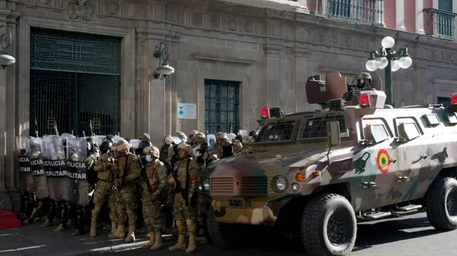 armoured vehicle and military police form outside the government palace in la paz