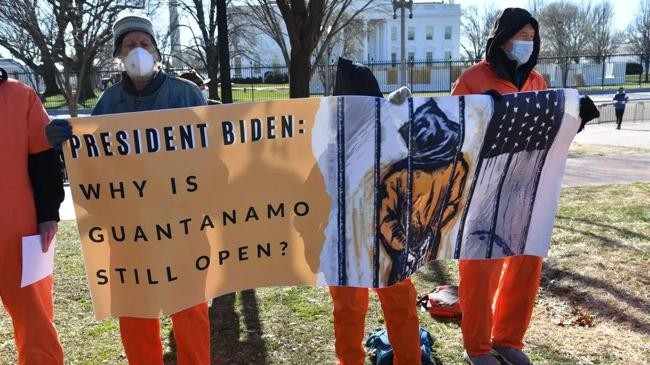 demonstrators hold a sign during a protest in front of the white house