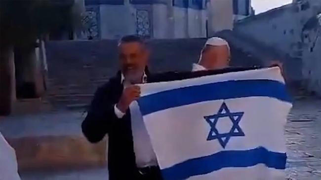 settler waves israel flag in al aqsa mosque courtyard