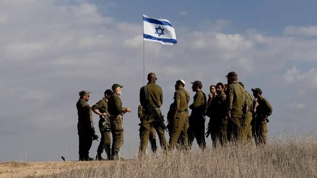 soldiers stand near an israeli flag