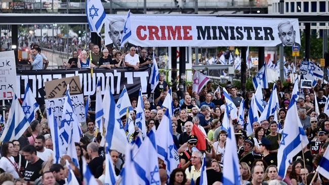 thousands holding banners and israeli flags gather during a demonstration